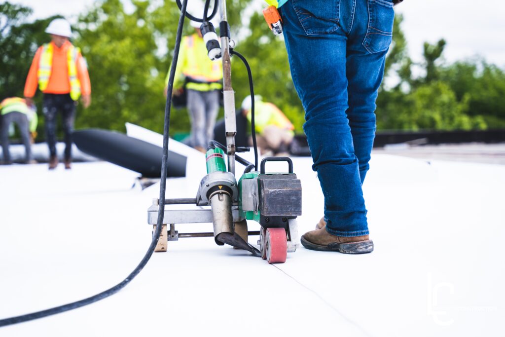 Commercial roofing contractors installing a roofing membrane