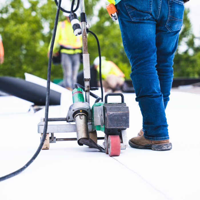 Commercial roofing contractors installing a roofing membrane