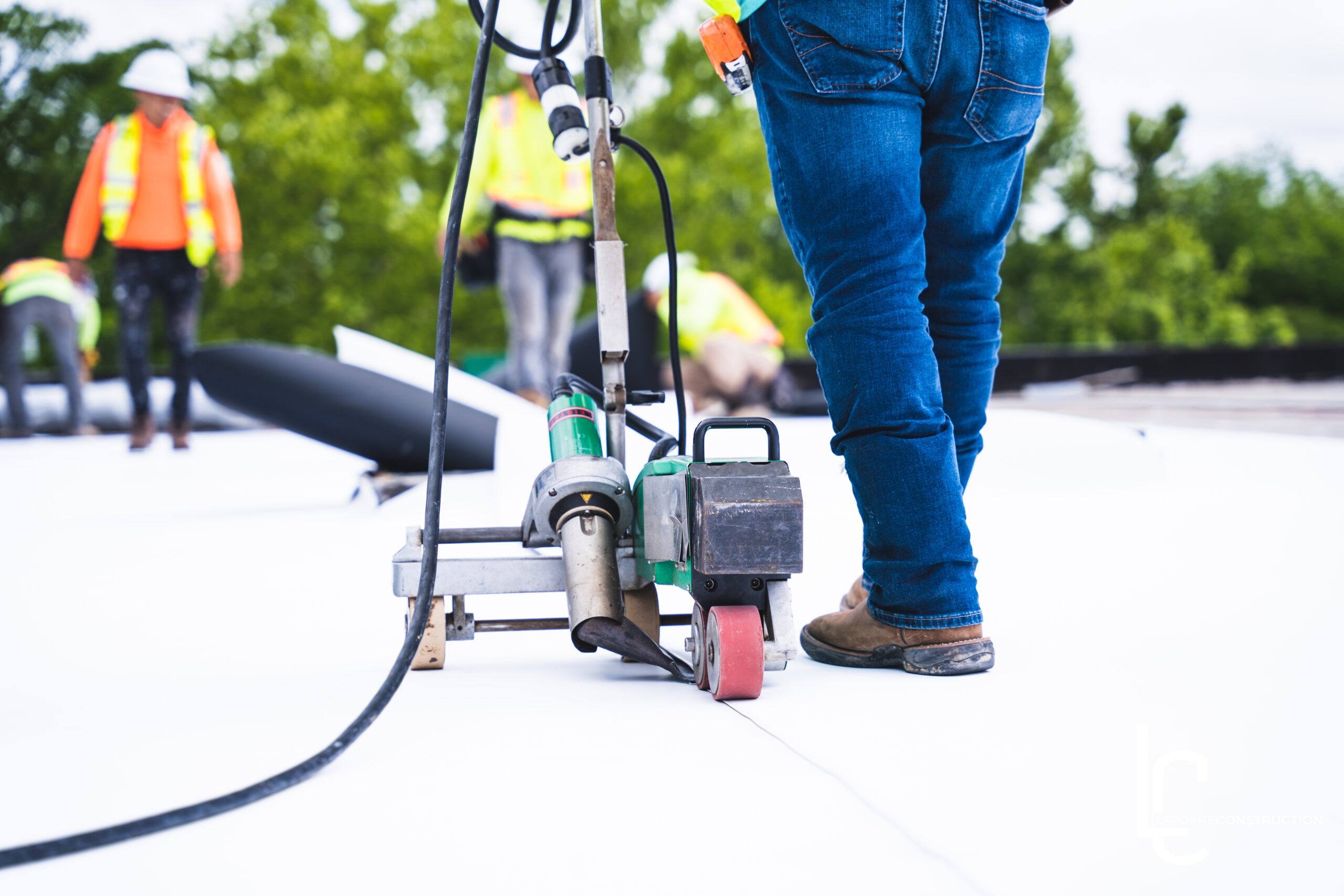 Commercial roofing contractors installing a roofing membrane